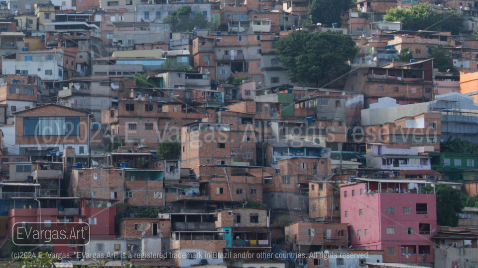 front view of hill with favela in city, blue sky with clouds