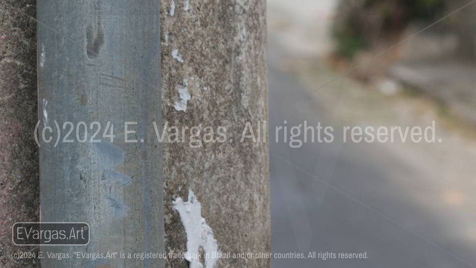 close-up of a vertical metal pipe next to a concrete pole, street, urban, daylight, outdoors