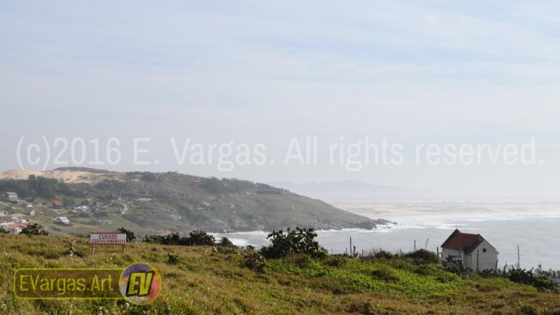 seacoast landscape seen from land, small church, daylight