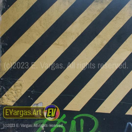 closeup of a street wall with yellow and black stripes painted on it