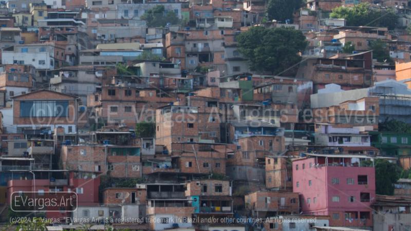 front view of hill with favela in city, blue sky with clouds