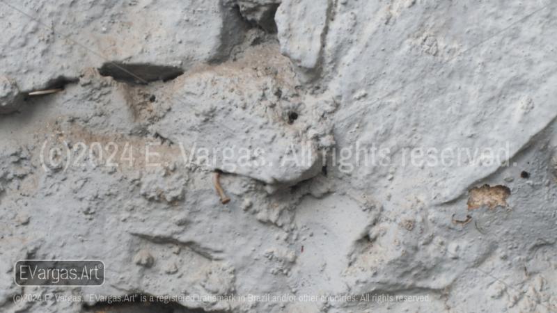 white textured wall, rock on the wall, shadows, sunlight, day, outdoors, close-up