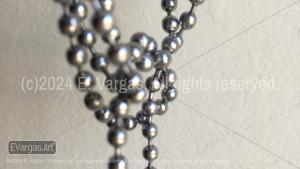 chains hanging in front of a white wall, indoors, sunlight