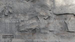 white textured wall, rock on the wall, shadows, sunlight, day, outdoors, close-up