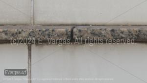 horizontal granite piece on dirty tile wall, urban, street, outdoors, daylight